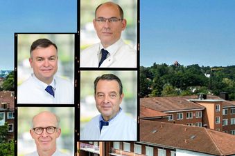 Vier Ärzte in weißen Kitteln sind als Porträtfotos über einem Krankenhausgebäude montiert.