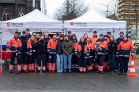 Alle Helfenden stehen als Team versammelt vor den aufgebauten Pavillons. 