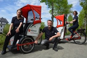 Drei Malteser Rikschafahrer mit ihrer Rikscha 