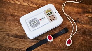 Nahaufnahme eines Hausnotrufgerätes, sowie der Uhr und Notrufkette.