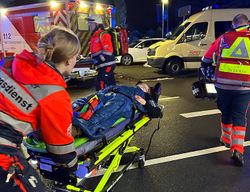 Zwei Personen in Malteser Einsatzkleidung schieben eine eine Trage mit einer verletzten Person