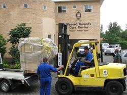 Ein Gabelstapler entlädt die gespendeten Wäschereigeräte vor dem Blessed Gérard’s Care Centre am 3. Dezember 2009.