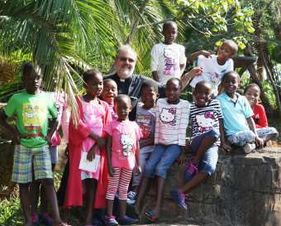 Kinder und Betreuende des Kinderheims stehen als Gruppe im Freien.