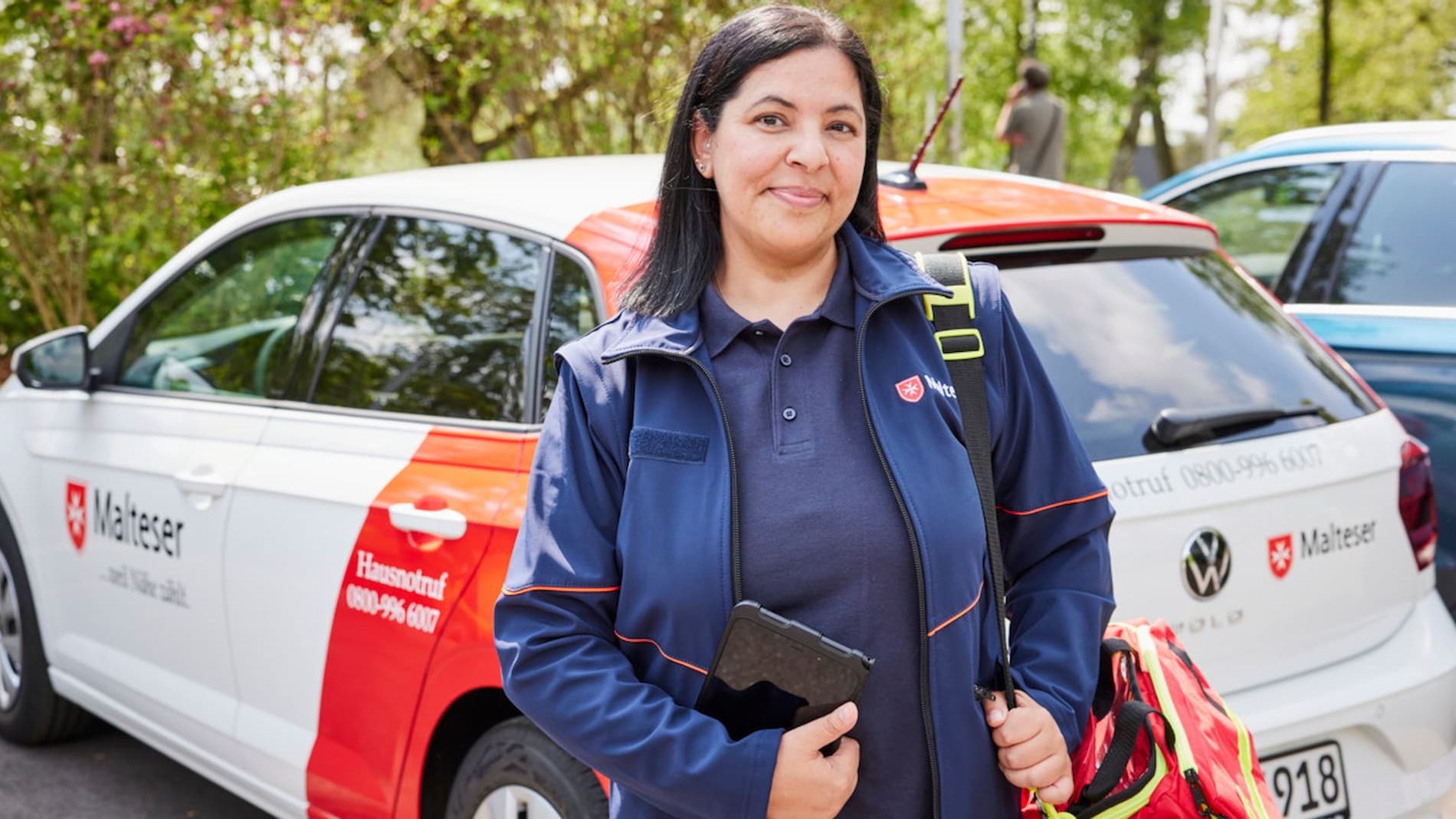 Malteser Hausnotruf Bereitschaftsdienstmitarbeiterin lächelt in die Kamera.
