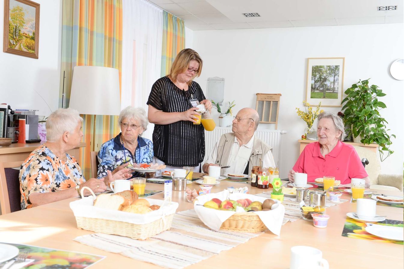 Bewohner frühstücken zusammen am Tisch 