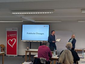 Zwei Teilnehmer üben Ehrungen im Rahmen eines kurzen Rollenspiels