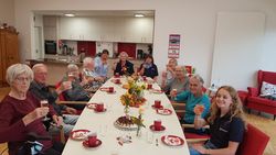 Senioren und Ehrenamtliche stoßen auf das Jubiläum an.