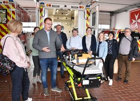 Ein Mann und eine Gruppe hinter einem Rettungswagen