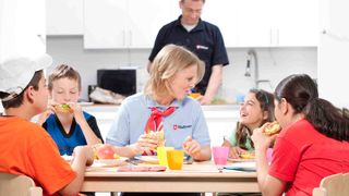 Malteser Betreuer essen mit Kindern