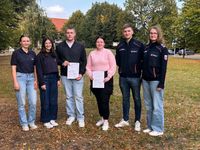 Ausbilderinnen und Leitungskräfte übergeben die Urkunden an zwei neue Helfer