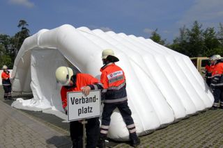 Helfer bauen ein Sanitätszelt auf