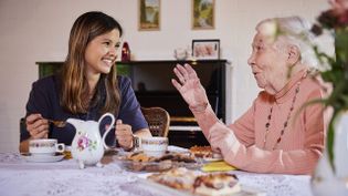 Eine Ehrenamtliche der Malteser besucht eine ältere Dame zu Hause.