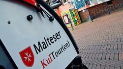 Eine Fahrradrikscha vor einem Hauswandgemälde in Hildesheim