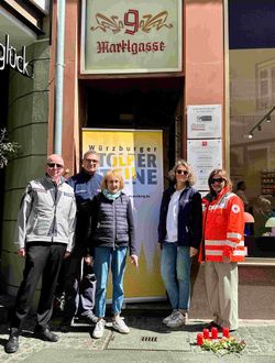 Gruppe Menschen vor Haustür mit Stolperstein