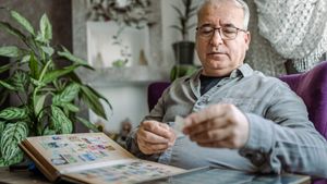 Ein älterer Mann sortiert seine Briefmarkensammlung.