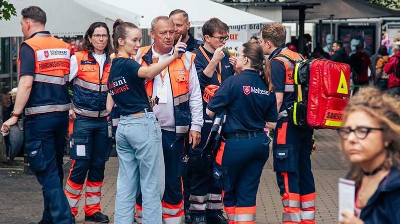 Eine Gruppe von Sanitäterinnen und Sanitätern bespricht sich.