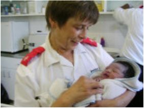 Care Centre staff member holding newborn Nothando