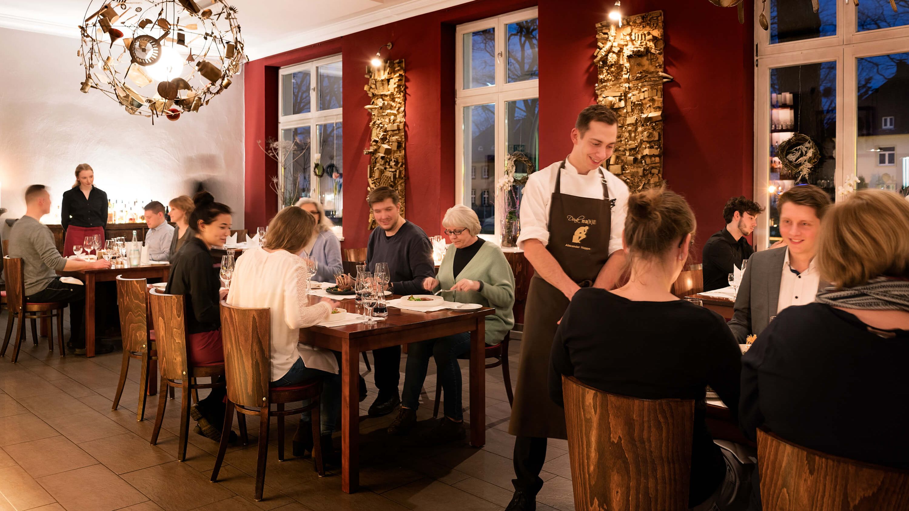 Koch unterhält sich mit Gästen im Restaurant