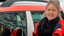 Eine Frau in Malteser Kleidung vor einem Malteser Dienstauto