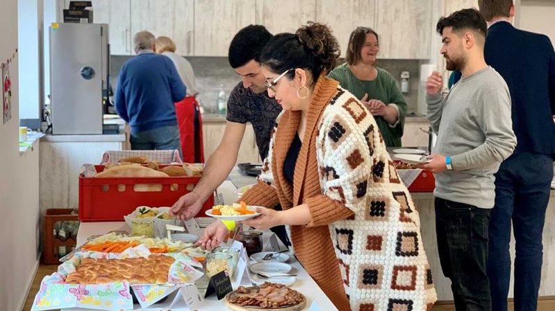 Menschen in einer Küche essen von einem Buffet