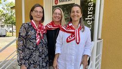 Drei Frauen stehen auf den Stufen einer Treppe und blicken freundlich in die Kamera.