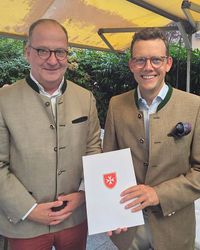 Patrick Tapp (links), Regionalleiter Hessen/Rheinland-Pfalz/Saarland, überreicht Ma-ximilian Graf von Plettenberg die Berufungsurkunde zum Diözesanleiter der Malteser im Bistum Limburg. (Foto: Malteser Limburg)