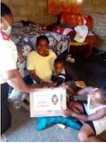 Übergabe eines Lebensmittelpakets an eine Familie mit Kindern nach der Flut in Hlomendlini