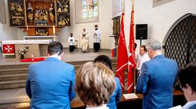 Menschen hören einem Gottesdienst zu.