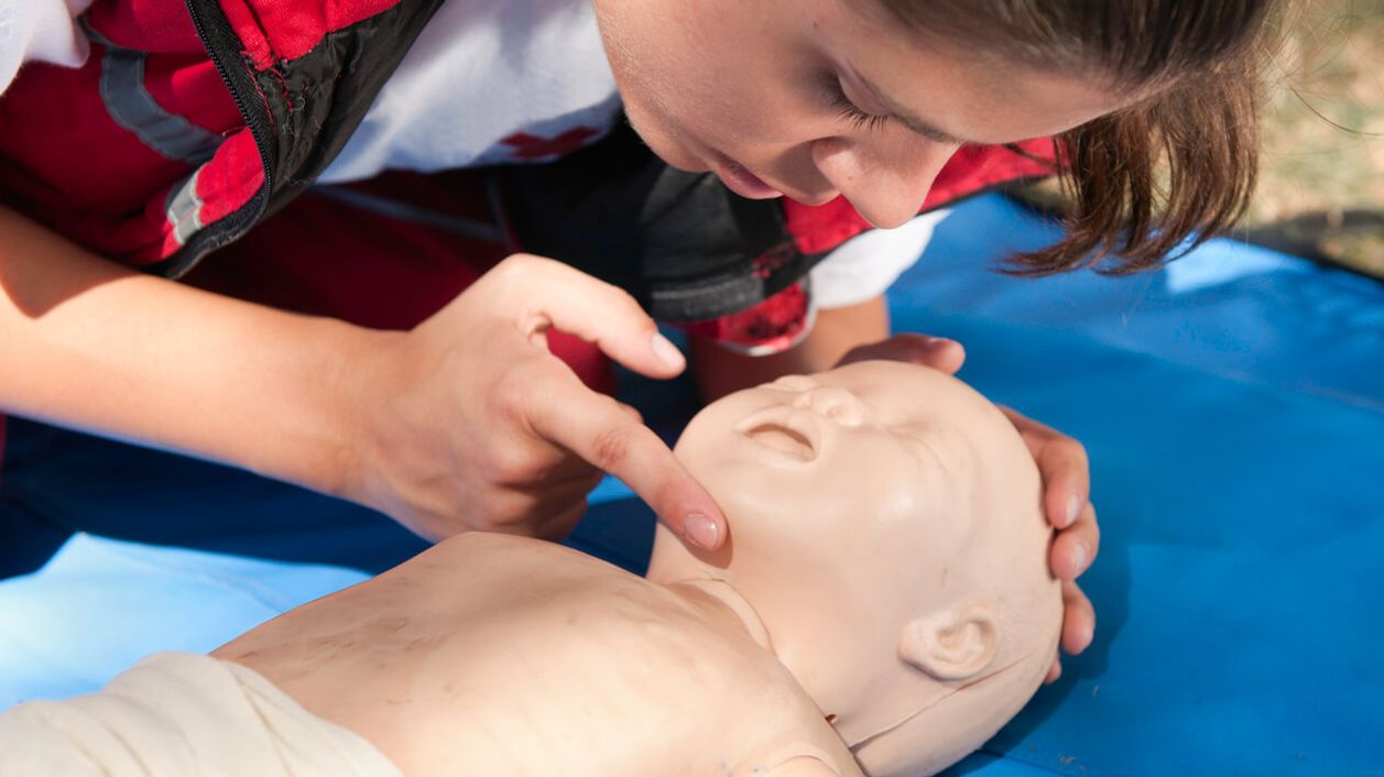 Junge Frau macht Wiederbelebung bei Kleinkindpuppe