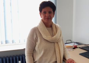 Mitarbeiterin steht in einem Büro am Schreibtisch