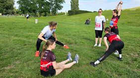 Mehrere Frauen in Sportkleidung machen sich warm.