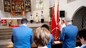 Menschen hören einem Gottesdienst zu.