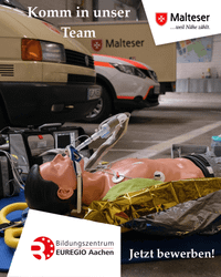 Eine Reanimationspuppe liegt auf dem Boden vor Einsatzfahrzeugen