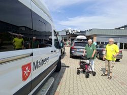 Ein Malteser-Kleinbus mit Logo steht auf dem Parkplatz der Holzofenbäckerei Ripken
