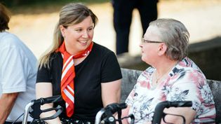 Eine Helferin der Malteser begleitet eine Dame bei einem Ausflug