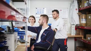 Malteser Mitarbeitende in Weiterbildungssituation, sitzen am Tisch mit Lehrunterlagen.