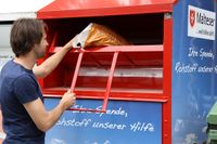 Mann wirft einen Sack in einen Malteser Altkleider Container