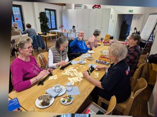 Seniorinnen und Senioren beim Spiele an einem Tisch 