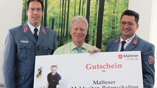 Gutschein Malteser Mahlzeitenpatenschaften wird überreicht.