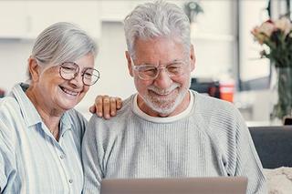 Älteres Paar schreibt am Laptop
