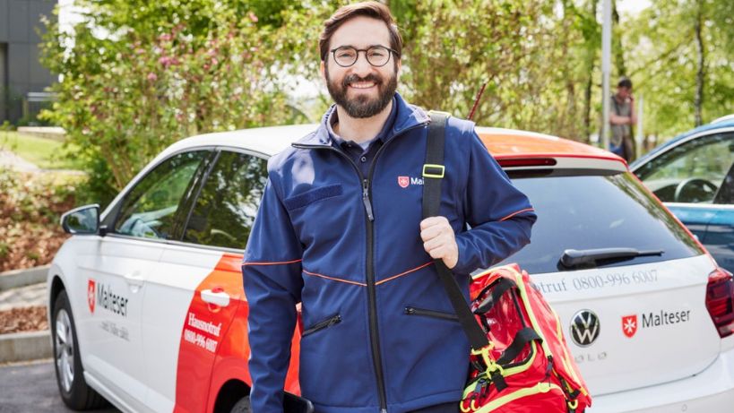 Malteser Hausnotruf Bereitschaftsdienstmitarbeiter lächelt in die Kamera.