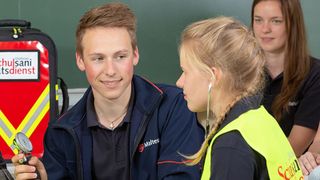 Schulsanitäter üben, wie man den Blutdruck misst.