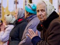 Mehrere ältere Frauen. Eine Frau schaut in die Kamera