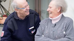 Ein Ehrenamtlicher spricht mit einer älteren Dame