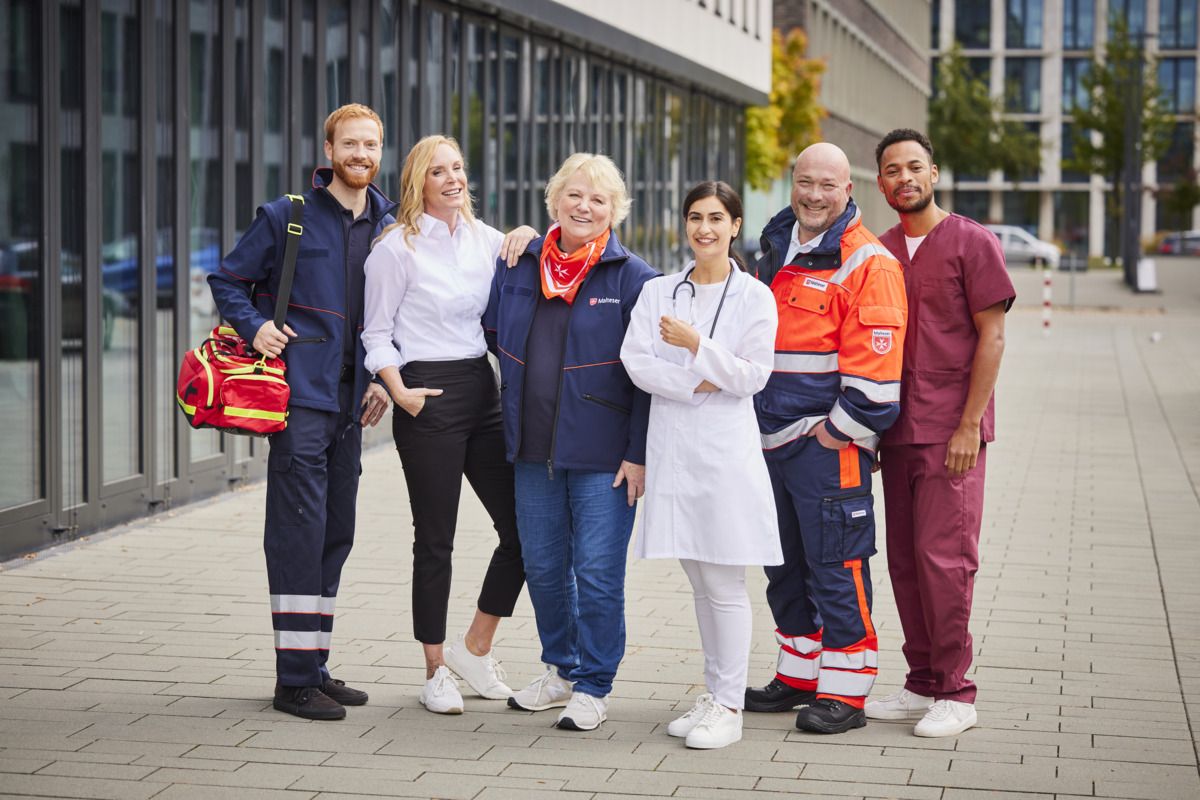 Sechs Personen in unterschiedlicher Malteser Dienstkleidung stehen nebeneinander