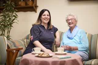 Zwei ältere Damen unterhalten sich im Garten