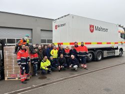 Mehrere Menschen stehen vor einem LKW