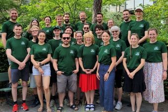 Eine größere Anzahl von Menschen als Gruppe vor einem Gebäude