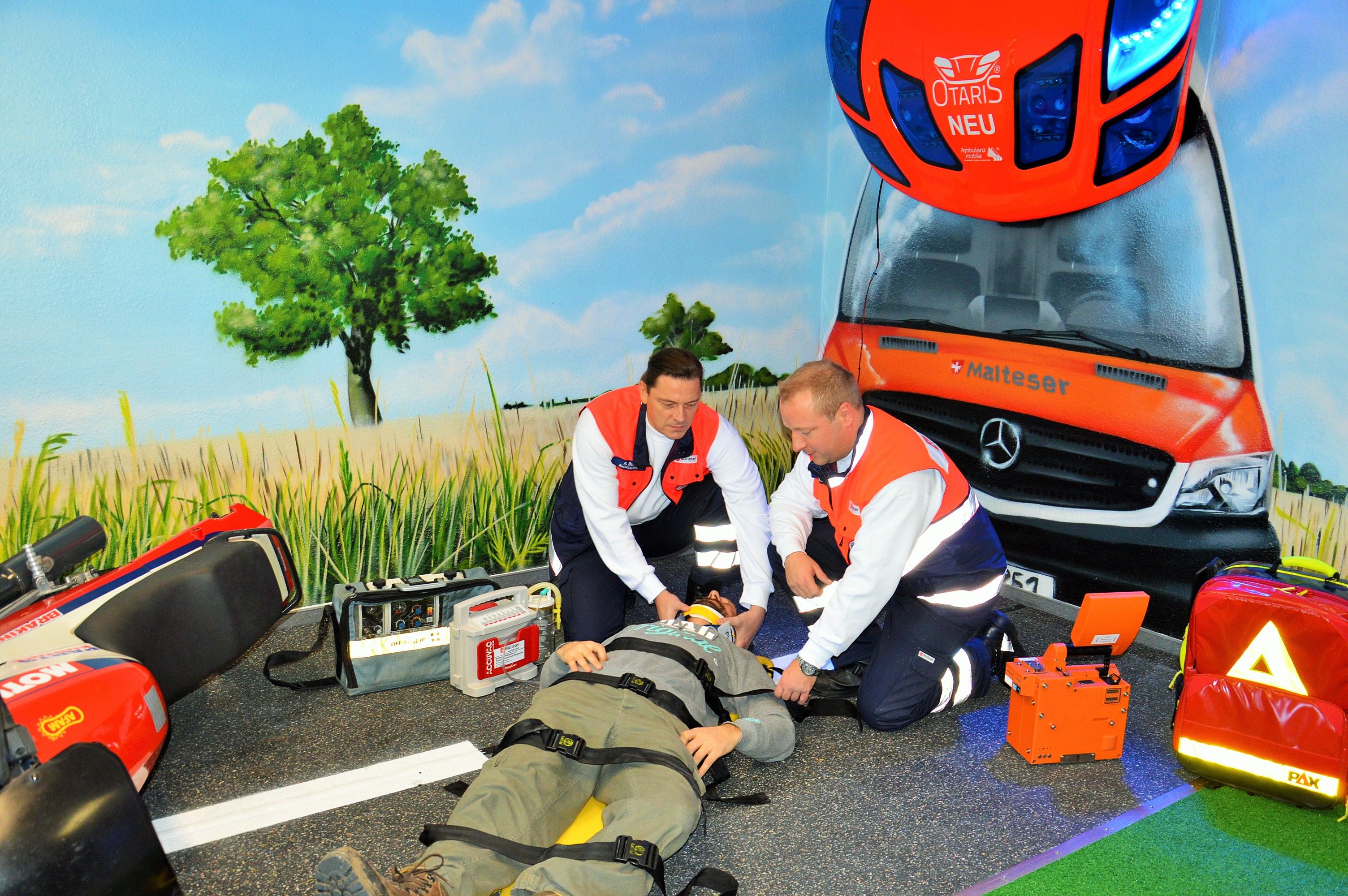 Zwei Mitarbeiter der Malteser simulieren in der RettArena einen Motorradunfall.