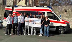 Gruppe Menschen vor Herzenswunsch-Krankenwagen